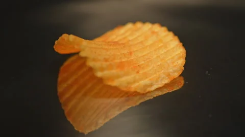Single crispy golden potato chip rotation in slow motion. Fast food and jun.. Stock Footage 325635097