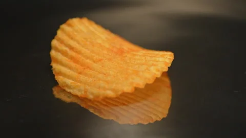 Single crispy golden potato chip rotation in slow motion. Fast food and jun.. Stock Footage 325635100