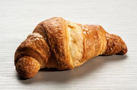 Single croissant on white table Foto stock