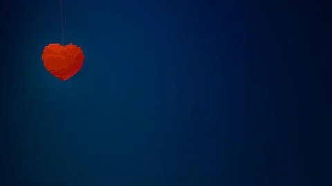 Single cubic heart shape hanging on string positioned to the left against a.. Stock Illustration