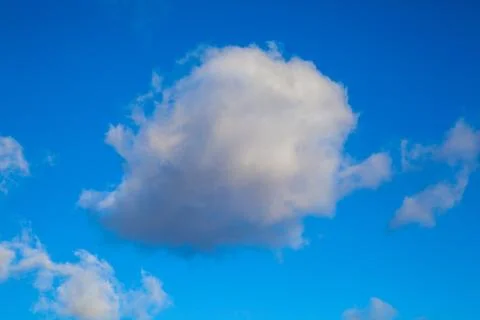 Single Cumulus Cloud on blue light sky Stock Photos