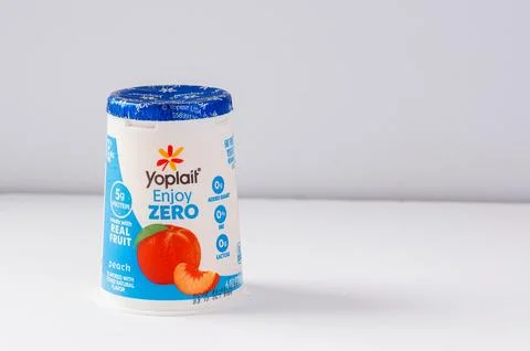 A single cup of Yoplait Enjoy Zero peach yogurt on a clean white background Stock Photos