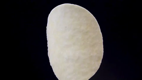Single Curved Potato Crisp Rotating on Black Background Vídeo Stock 345426547