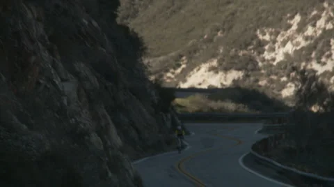 Single cyclist downhill follow Stock Footage 1065995