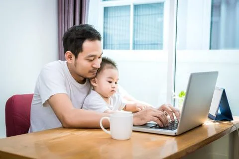 Single dad and son using laptop together happily. Technology and Lifestyles c Photos