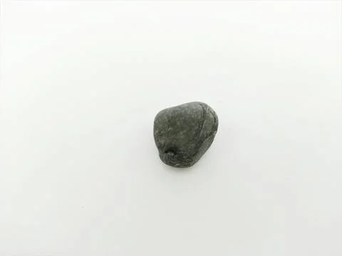 Single Dark Gray Smooth Pebble Centered on a Clean White Background Stock Photos