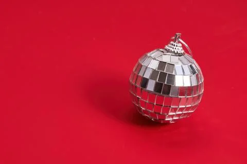 Single Disco Ball. A shiny silver disco ball on a vibrant red background. Stock Photos