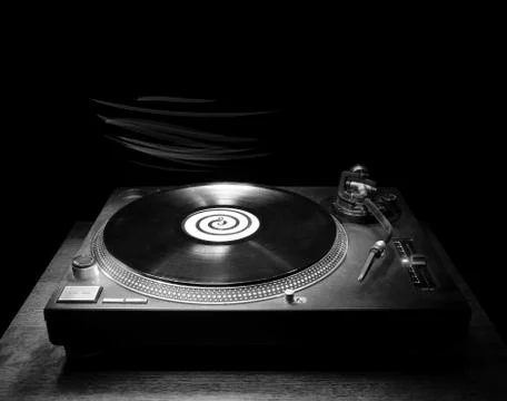Single dj turntable record player sitting on a small wooden table in the dark Stock Photos