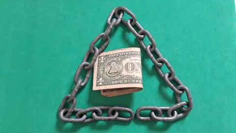 Single dollar bill trapped inside a heavy metal triangle chain Stock Photos