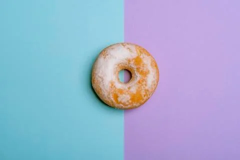 Single donut on a blue-violet background. Minimalism flat lay image Stock Photos
