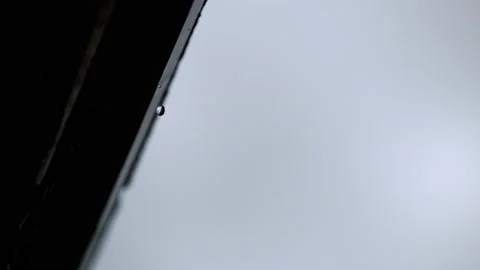 Single drop fall from the edge of roof, in super slow motion, 4k Stock Footage 204030040