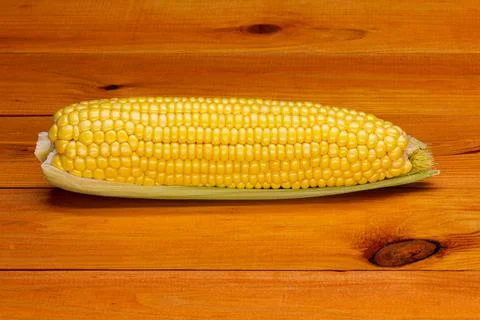 Single ear of corn on the background of a beautiful wooden table Stock Photos