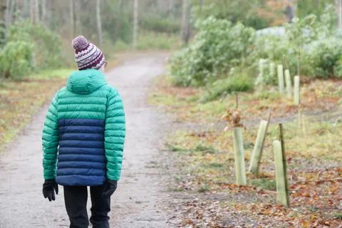 Single elderly woman walking alone in forest during lockdown for good mental and Foto stock