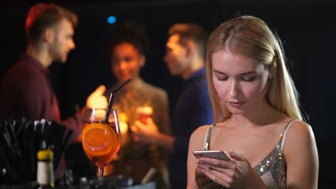 Single elegant female using phone in night club Stock-Footage 105576432