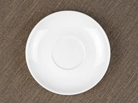 Single Empty White Plate on Coarse Fabric or Bagging Background Stock Photos