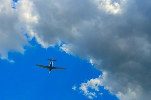 Single-engine aircraft in the bright sky against the backdrop of a thunderclo Stock-Fotos