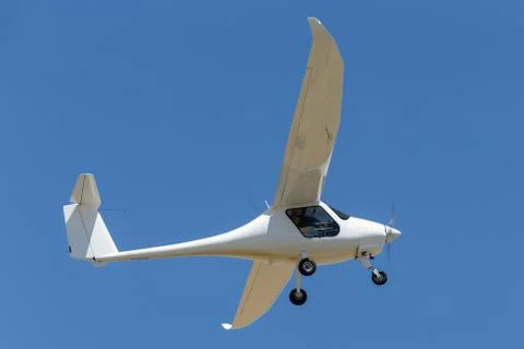 Single engine light aircraft flying against a blue sky. Stock Photos