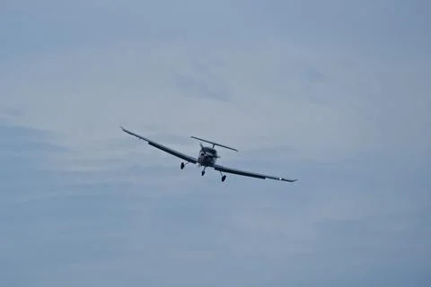 Single-engine plane approaching the airport under a cloudy sky 스톡 사진