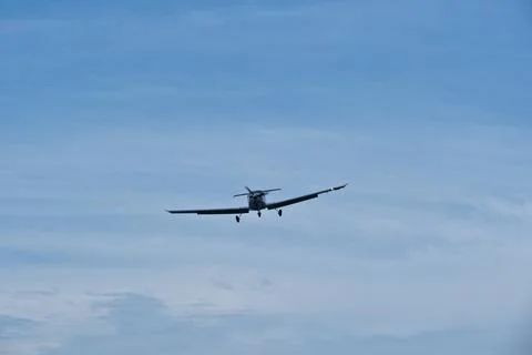 Single-engine plane approaching the airport under a cloudy sky Foto stock