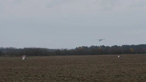 A single-engine private plane lands against the backdrop of an autumn landscape. Video stock 146827215