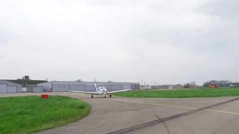 Single engine propeller airplane is standing in front of a closed aircraft Stock Footage 239069133