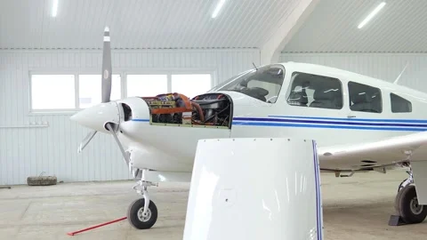 Single engine propeller airplanes parked in a closed aircraft hangar. Internal Stock Footage 239071780