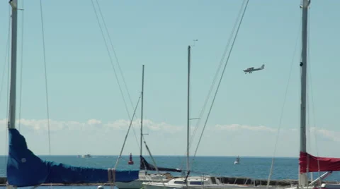 Single engine propeller plane landing at airport by the lake and marina. 4K U Video stock 53765435