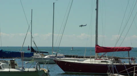 Single engine propeller plane landing at airport by the lake and marina. 4K U Stock-Footage 53767323