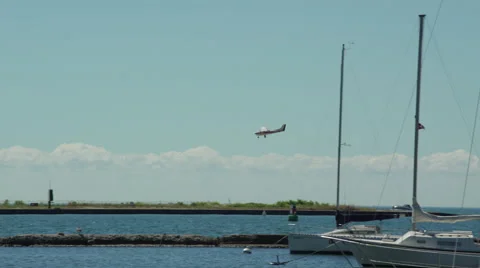 Single engine propeller plane landing at airport by the lake and marina. 4K U 스톡 동영상 53768246