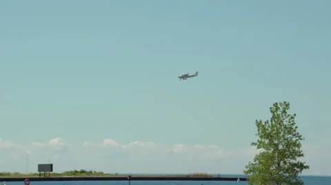 Single engine propeller plane landing at airport by the lake and marina. 4K Stock Footage 53769965