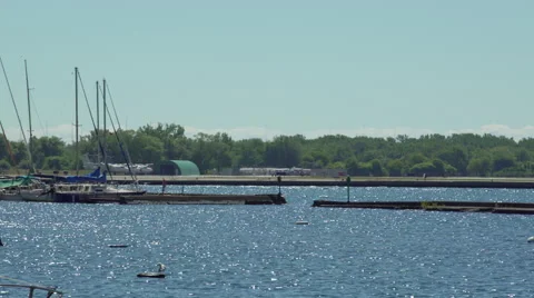 Single engine propeller plane taking off at airport by the lake and marina. Stock Footage 53772271