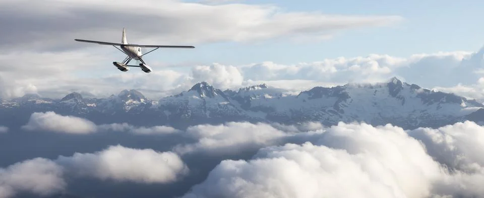 Single Engine Seaplane Flying over the Rocky Mountain Landscape. Ilustração Stock