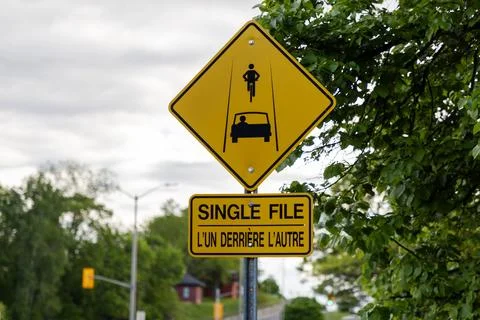Single file sharing road bilingual sign in Ottawa, Canada. Bicycle and car sa Stock-Fotos
