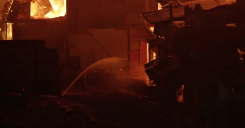 Single fire hose battles intense fire inferno in poor settlement Video stock 65786052