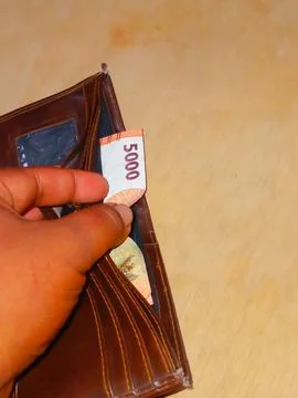 Single Five Thousand Rupiah Banknote Inside a Brown Wallet Stock Photos