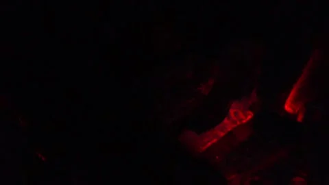 Single flame glowing on burning wood in darkness Stock Footage 336532555