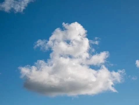 Single fluffy cloud in a blue sky 写真素材