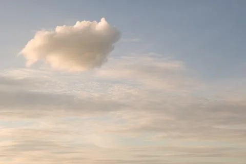 Single fluffy cloud in evening sky background Foto stock