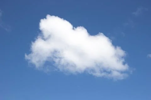 Single fluffy white cumulus cloud floating on deep blue sky Stock Photos
