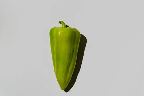 Single fresh green pepper with shadow on a plain grey background Foto stock