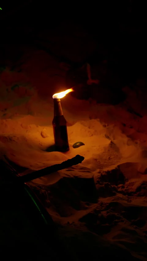 A single glass bottle with a bright flame burning from its neck illuminates Stock Footage 310491145