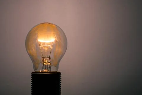 Single glass bulb mounted in socket with flame and smoke inside Stock Photos