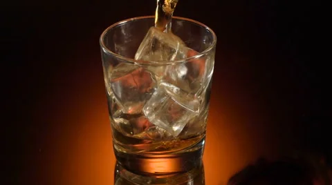 Single glass of whisky bourbon on ice on shiny background Stock Footage 65780829
