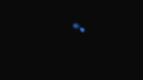 A single glowing blue light dot isolated against a deep black background Stock Footage 339615154