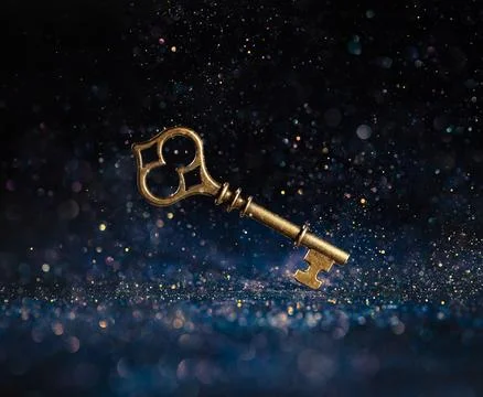 Single golden skeleton key surrounded by sparkling lights. Business concept.. Stock Photos