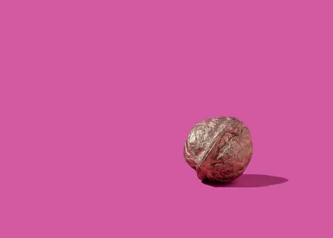 Single golden walnut on pink background Stock Photos