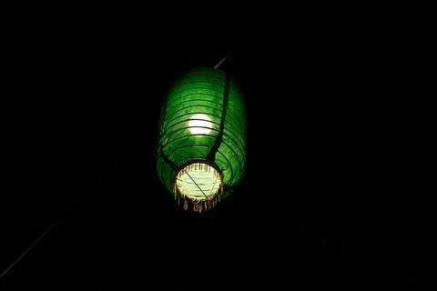 Single Green Eid Lantern Glowing in Complete Darkness 写真素材