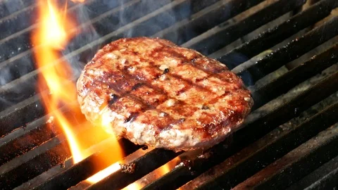 Single hamburger is cooking on the grill Video stock 98399115