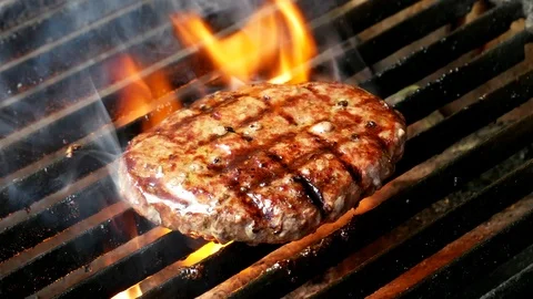 Single hamburger is cooking on the grill Video stock 98399666