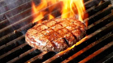 Single hamburger is cooking on the grill Video stock 98401298